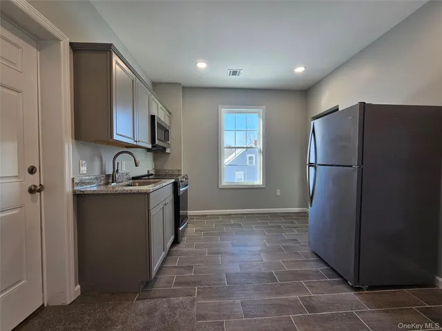 a kitchen with stainless steel appliances granite countertop a refrigerator and a sink