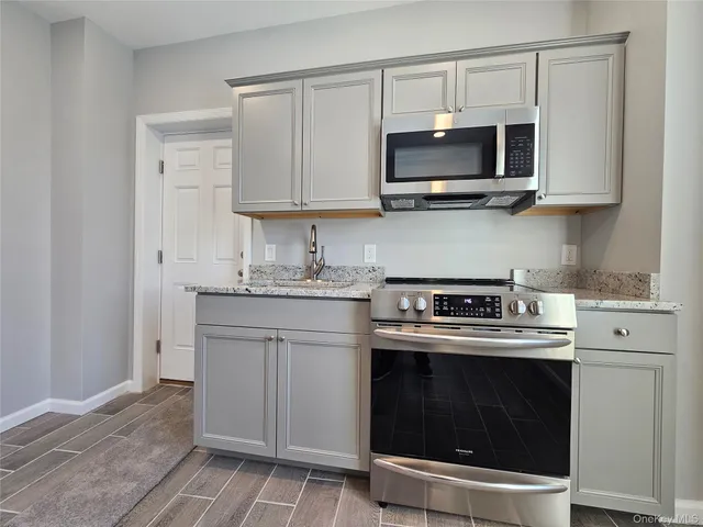 a kitchen with stainless steel appliances granite countertop a stove a microwave and cabinets
