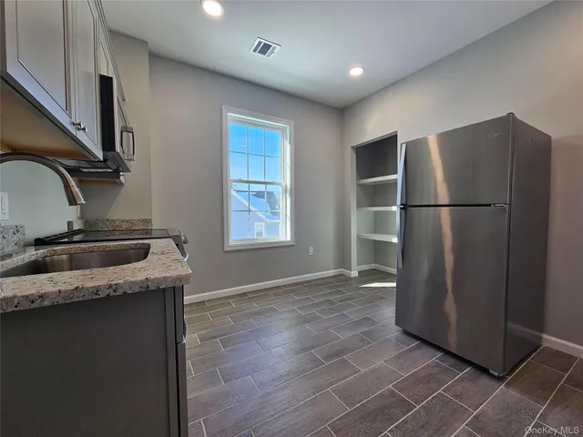 a kitchen with a refrigerator sink and cabinets