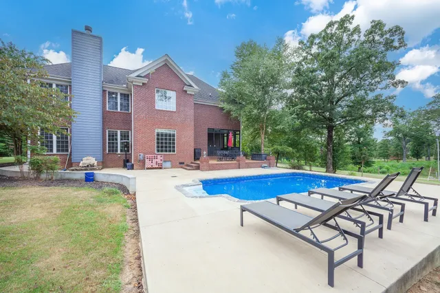 a view of swimming pool with chairs and tables