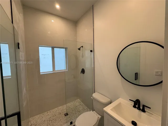 a bathroom with a sink mirror and toilet