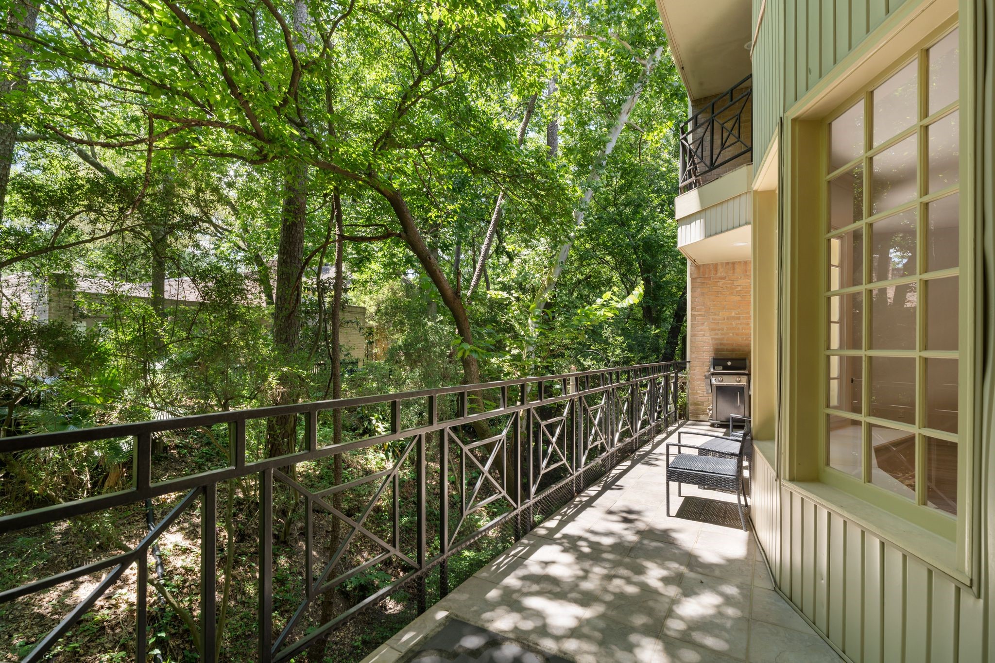 201 Vanderpool Lane, Unit 137 Houston, TX 77024 - Photo 16 of 42 Another view from the balcony highlights the lush greenery and mature trees surrounding the home, offering a private feeling outdoor space just off of the main living areas.