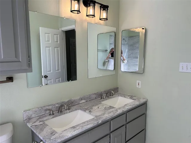 a bathroom with a granite countertop sink and a mirror