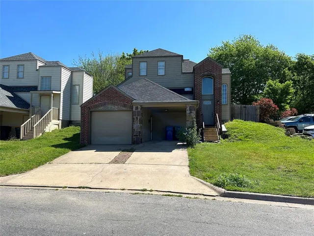 a front view of a house with a garden and yard