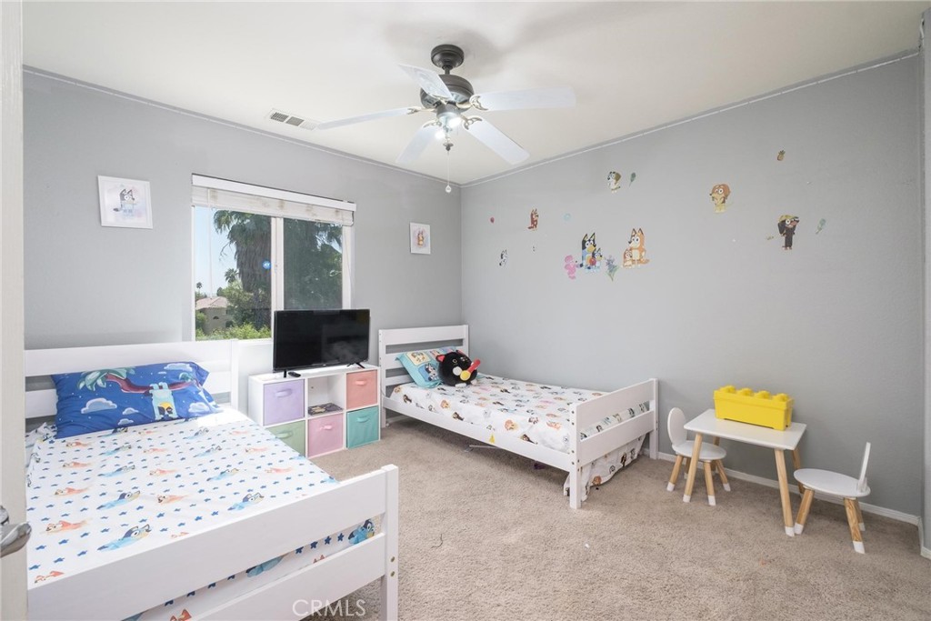 7940 Shadow Trails Lane Jurupa Valley, CA 92509 - Photo 18 of 34 a bedroom with a bed and a chandelier