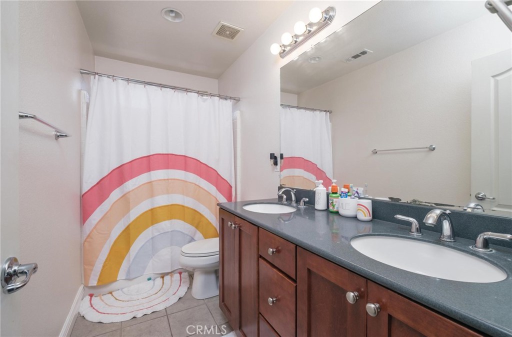 7940 Shadow Trails Lane Jurupa Valley, CA 92509 - Photo 20 of 34 a bathroom with a sink a toilet and a mirror