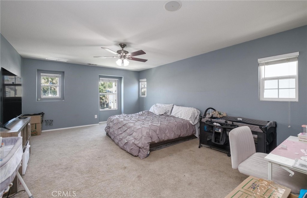 7940 Shadow Trails Lane Jurupa Valley, CA 92509 - Photo 21 of 34 a spacious bedroom with a bed and window