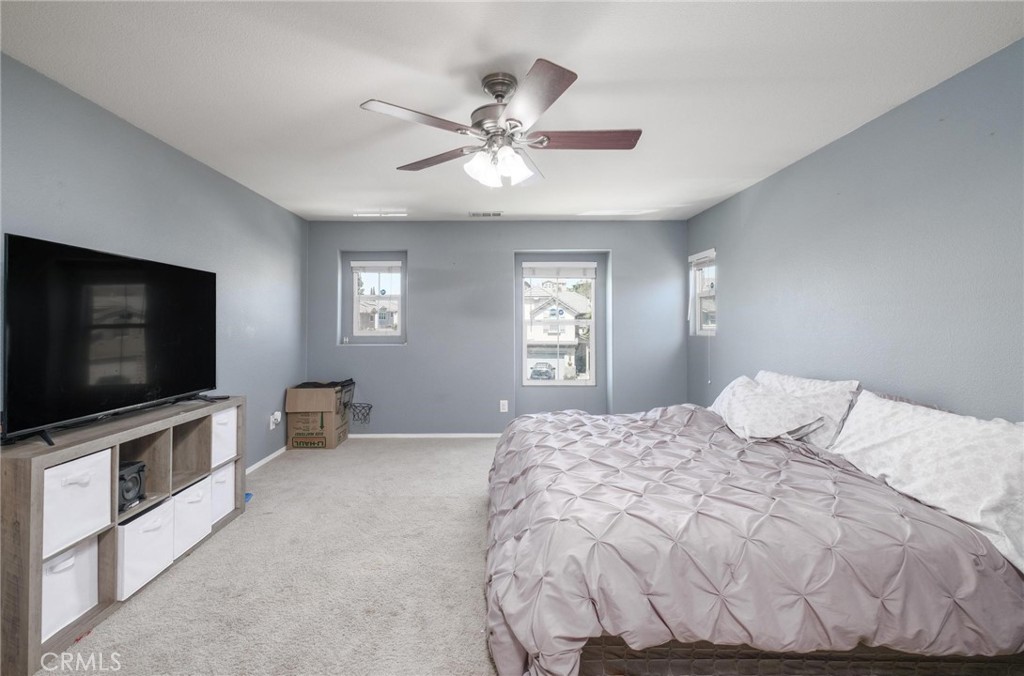 7940 Shadow Trails Lane Jurupa Valley, CA 92509 - Photo 22 of 34 a bedroom with a bed and a flat screen tv