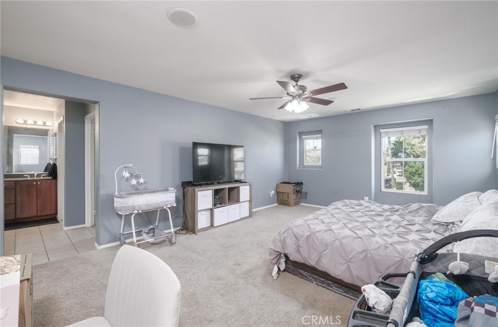 7940 Shadow Trails Lane Jurupa Valley, CA 92509 - Photo 23 of 34 a bedroom with a bed and a chandelier