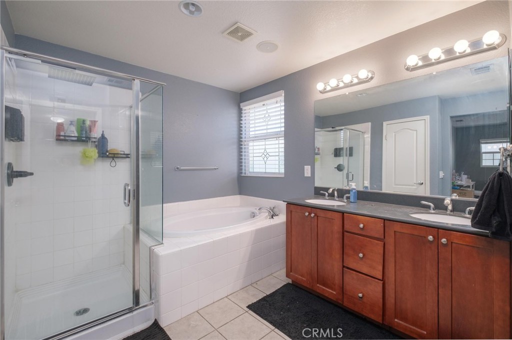7940 Shadow Trails Lane Jurupa Valley, CA 92509 - Photo 24 of 34 a spacious bathroom with a tub sink and mirror