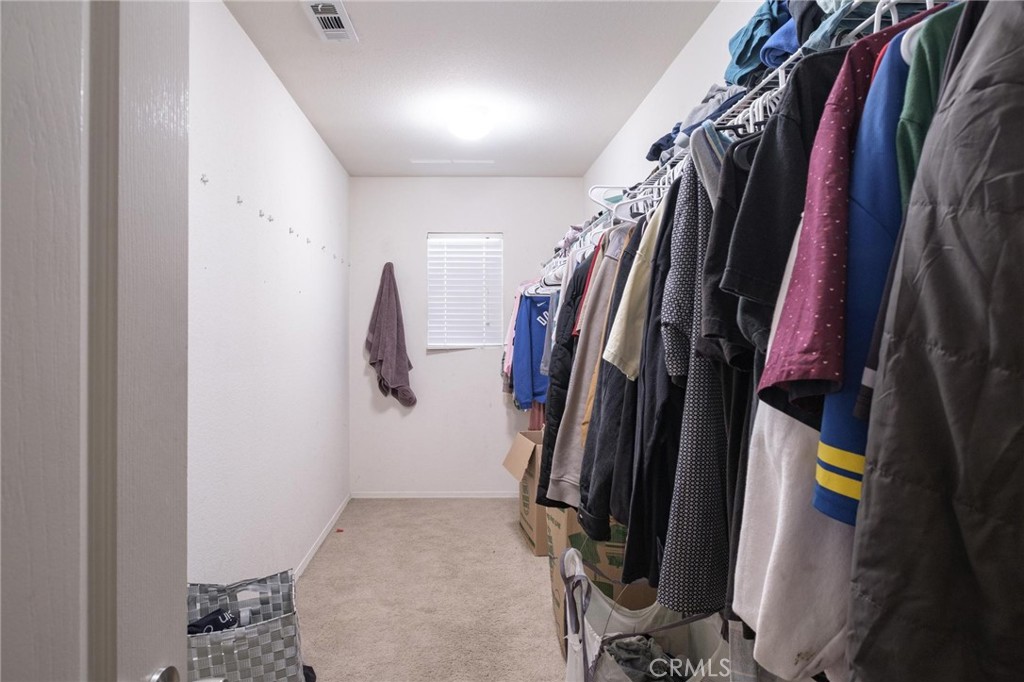 7940 Shadow Trails Lane Jurupa Valley, CA 92509 - Photo 25 of 34 a view of walk in closet with clothes and shoes