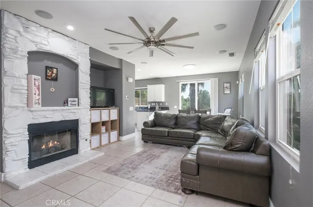 a living room with furniture a flat screen tv and a fireplace