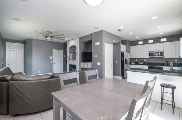 a kitchen with stainless steel appliances kitchen island granite countertop a refrigerator and a stove top oven