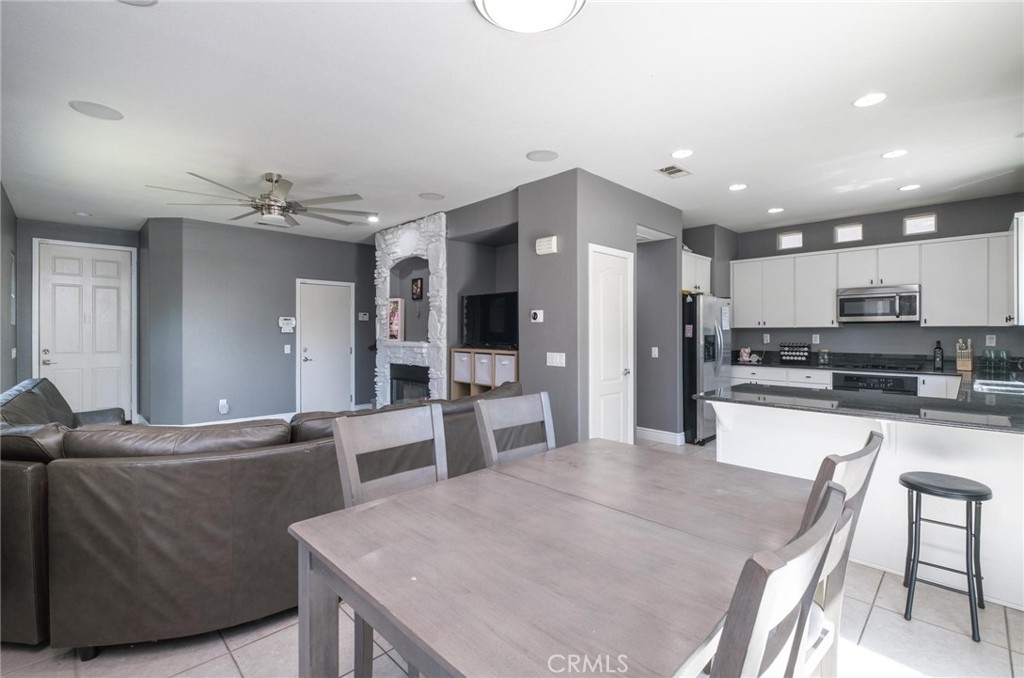 7940 Shadow Trails Lane Jurupa Valley, CA 92509 - Photo 8 of 34 a kitchen with stainless steel appliances kitchen island granite countertop a refrigerator and a stove top oven