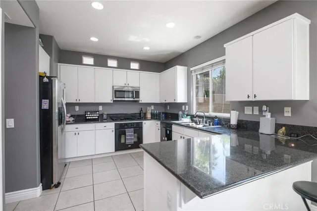 a kitchen with a refrigerator a sink a stove a microwave and cabinets