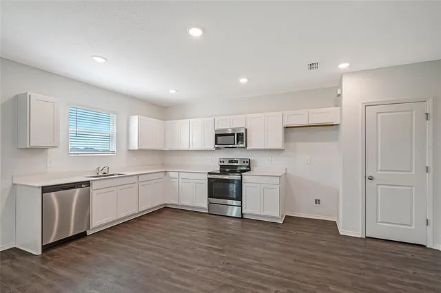 a large kitchen with stainless steel appliances granite countertop a stove and a refrigerator