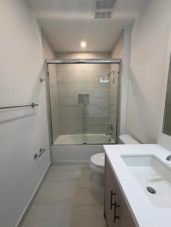 a bathroom with a sink a toilet and shower