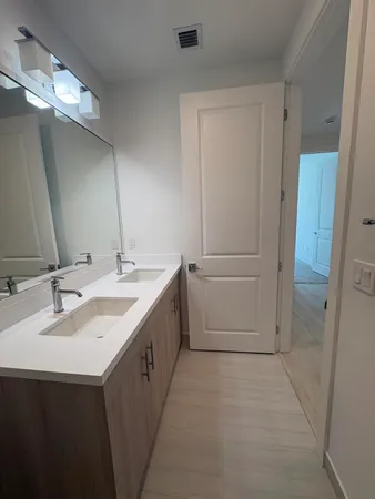 a bathroom with a double vanity sink and mirror