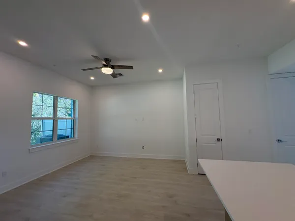 an empty room with a window and a ceiling fan