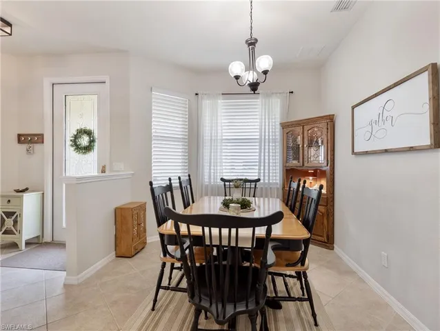 a dining room with furniture a chandelier and wooden floor