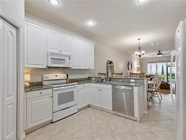 a kitchen with appliances a sink and cabinets
