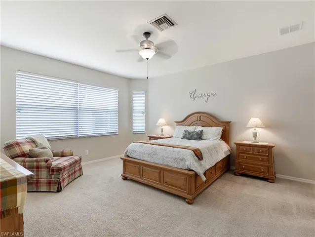 a spacious bedroom with a bed and a chandelier