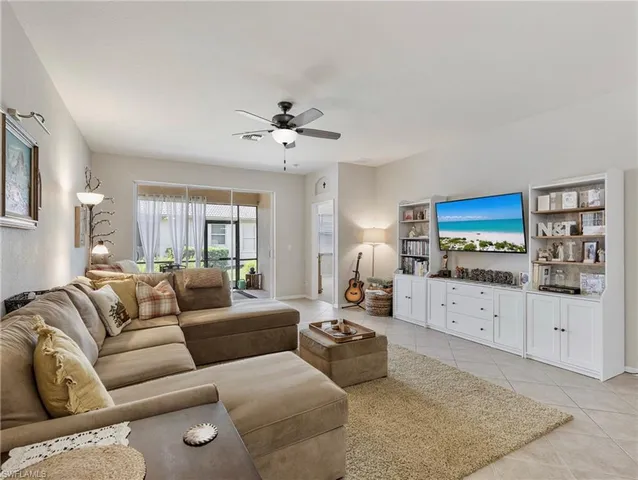 a living room with furniture a ceiling fan and a flat screen tv