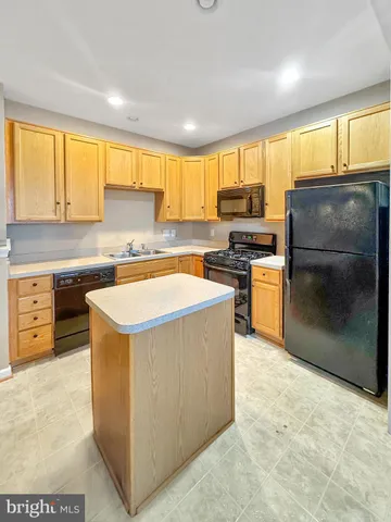 a kitchen with stainless steel appliances granite countertop a stove a sink a refrigerator and a microwave