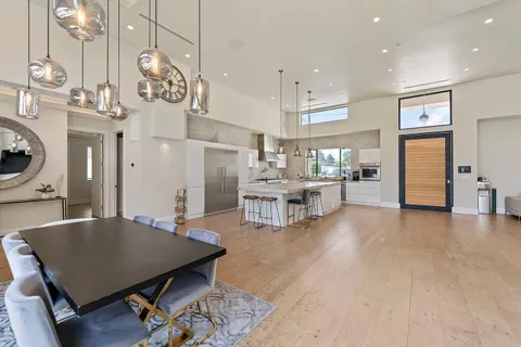 a living room with lots of furniture dining table and a chandelier