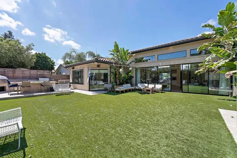 a view of a house with backyard porch and sitting area