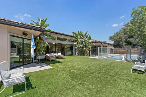 a backyard of a house with table and chairs