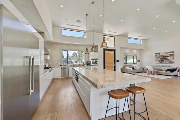 a large kitchen with stainless steel appliances lots of counter space and wooden floor