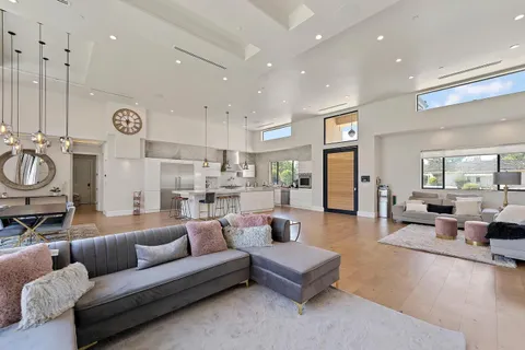 a living room with furniture kitchen view and a window