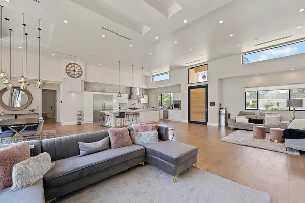 a living room with furniture kitchen view and a window