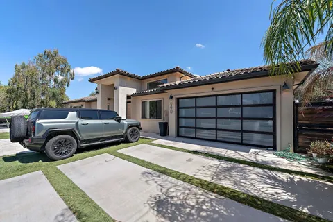 a view of a house with a large space and a car parked in front of it
