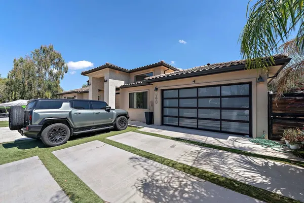 a view of a house with a large space and a car parked in front of it