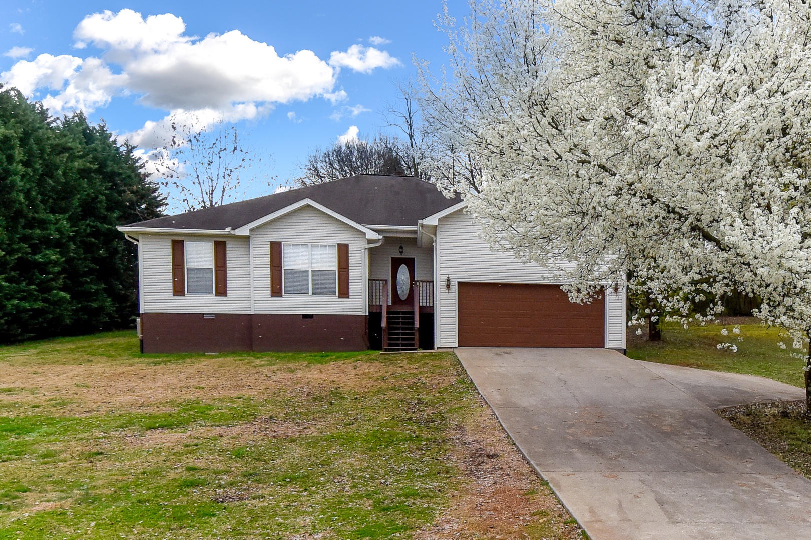 a front view of a house with a garden and trees