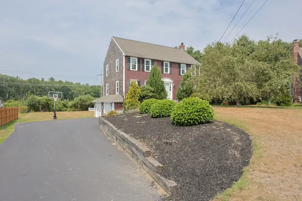 a view of a house with a yard and potted plants