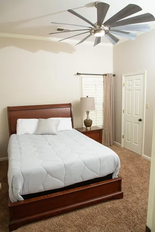 a bedroom with a bed and a ceiling fan