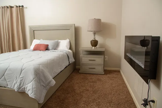 a bedroom with a bed and a night stand