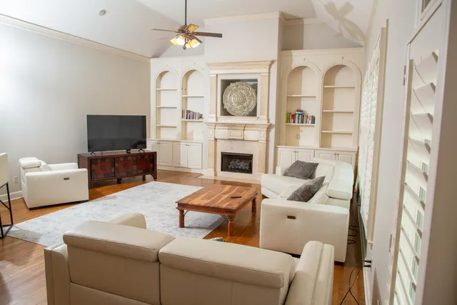 a living room with furniture a fireplace and a flat screen tv