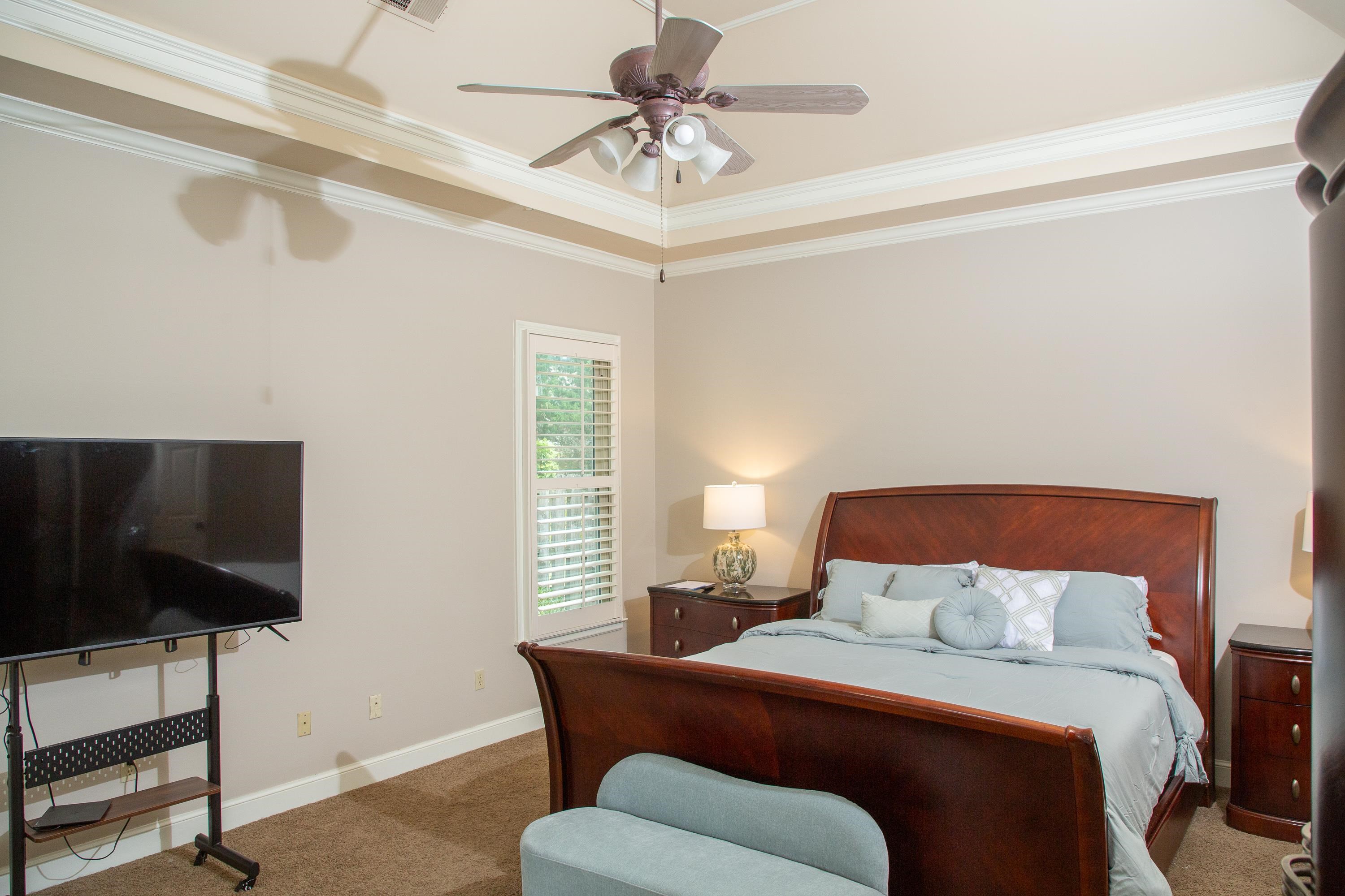 10060 Avent Ridge Cove Collierville, TN 38017 - Photo 32 of 40 a bedroom with a bed a couch and a flat screen tv