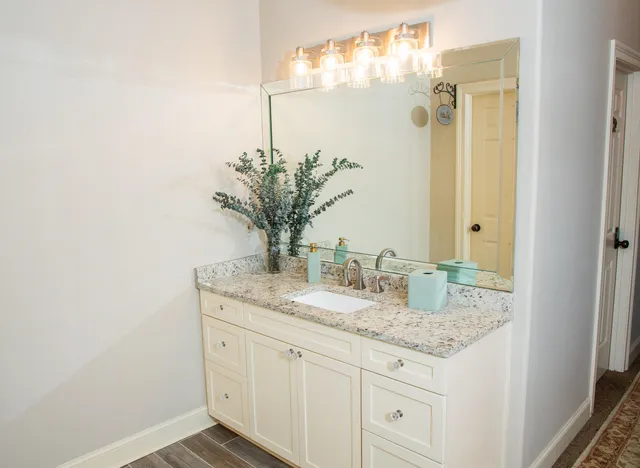 a bathroom with a granite countertop sink and a mirror