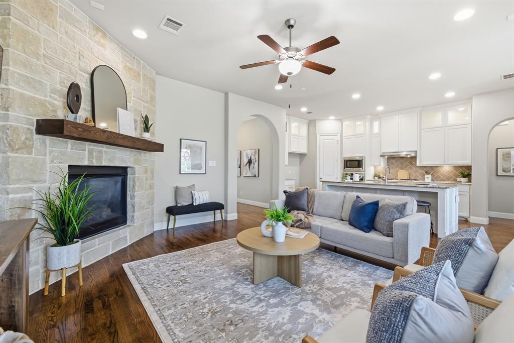 Downstairs living area with stone fireplace, open to the kitchen and breakfast area, and overlooking the backyard with pool and spa—perfect for entertaining.