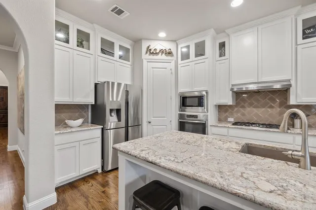a kitchen with stainless steel appliances granite countertop a refrigerator sink and stove