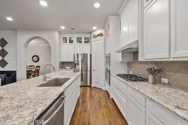 a kitchen with stainless steel appliances granite countertop a sink stove and refrigerator