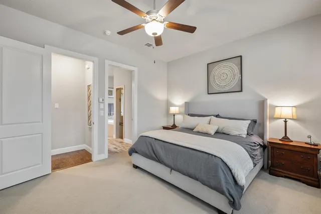 a spacious bedroom with a bed and a chandelier