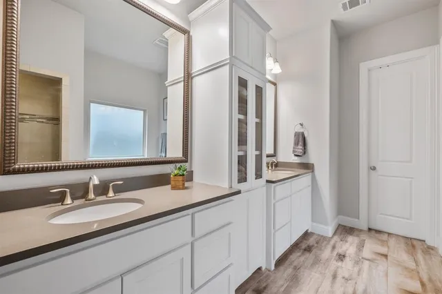 a bathroom with a granite countertop double vanity sink and a mirror