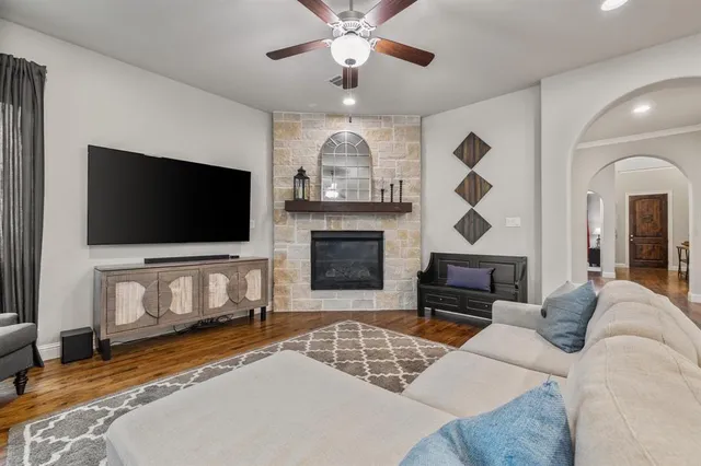 a living room with furniture a flat screen tv and a fireplace