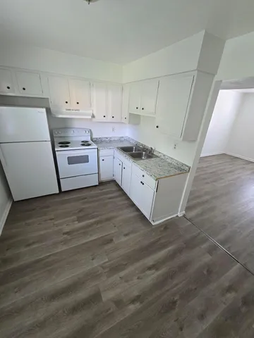 a kitchen with cabinets wooden floor and a sink